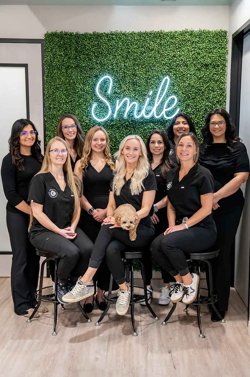 Knecht Orthodontics Team Photo in front of neon smile sign